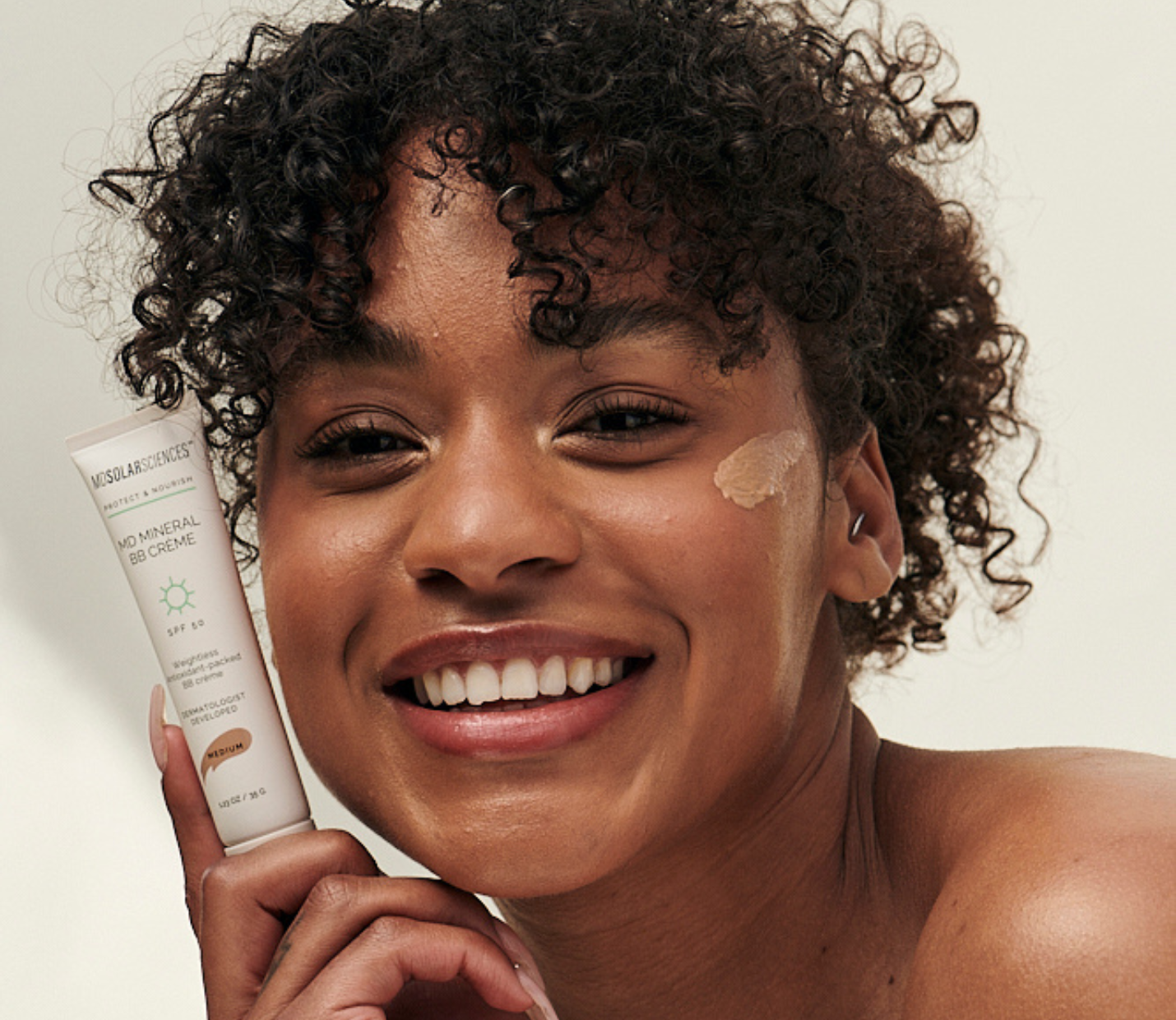 Woman applying sunscreen cream to her face
