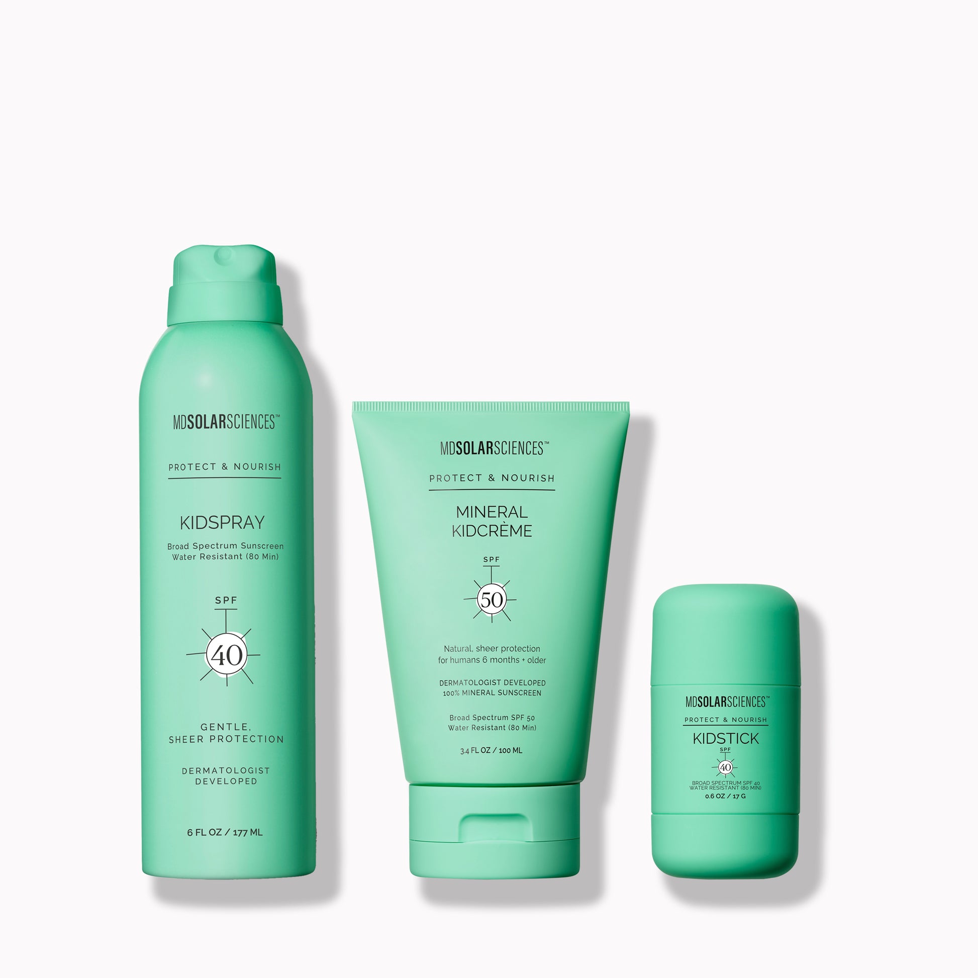 A set of three green-colored sunscreen products including a spray, a stick, and a cream, all labeled 'Just For Kids'.